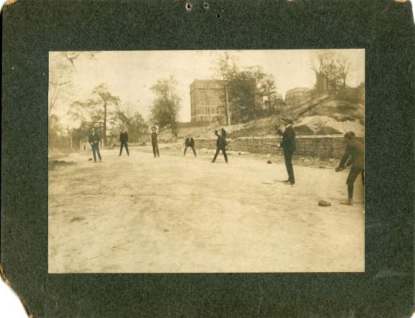 Men in Suits Playing Baseball in Street